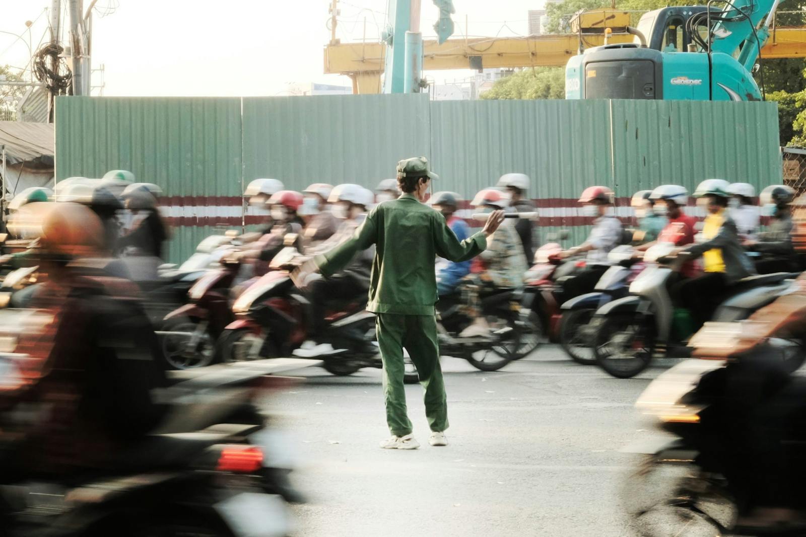 A city traffic officer manages busy urban street amidst rushing motorbikes.